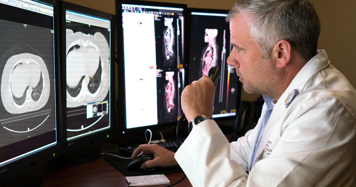 A male physician reviewing rare cancer screenings 
