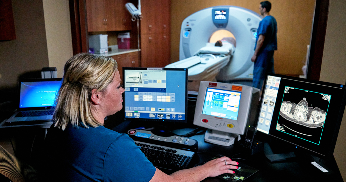 a radiology technician observing computer screens during a scan