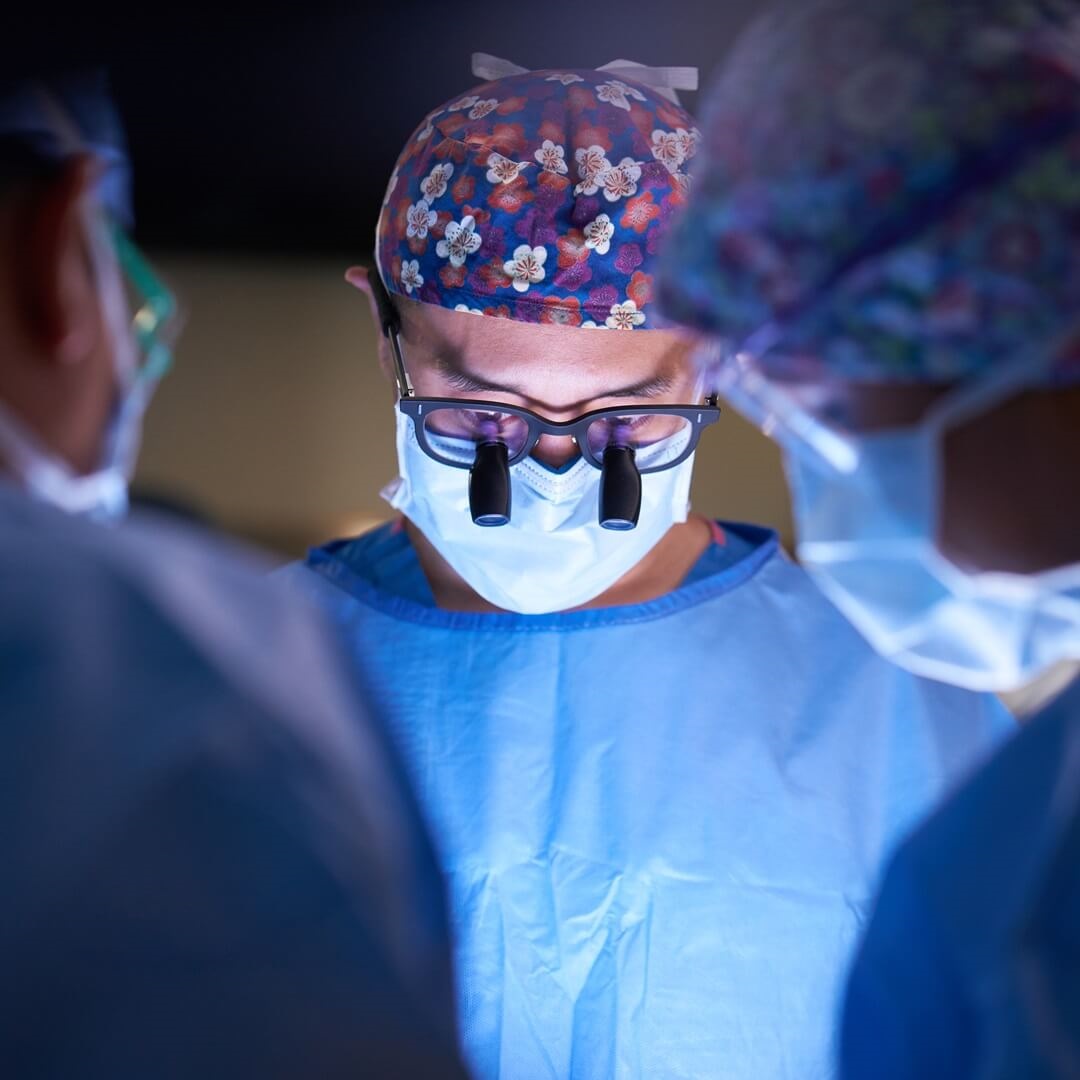 close up of doctor faces while performing surgery