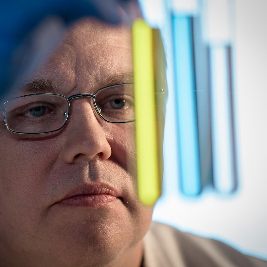 close-up of scientist evaluating lab test viles of multiple colors